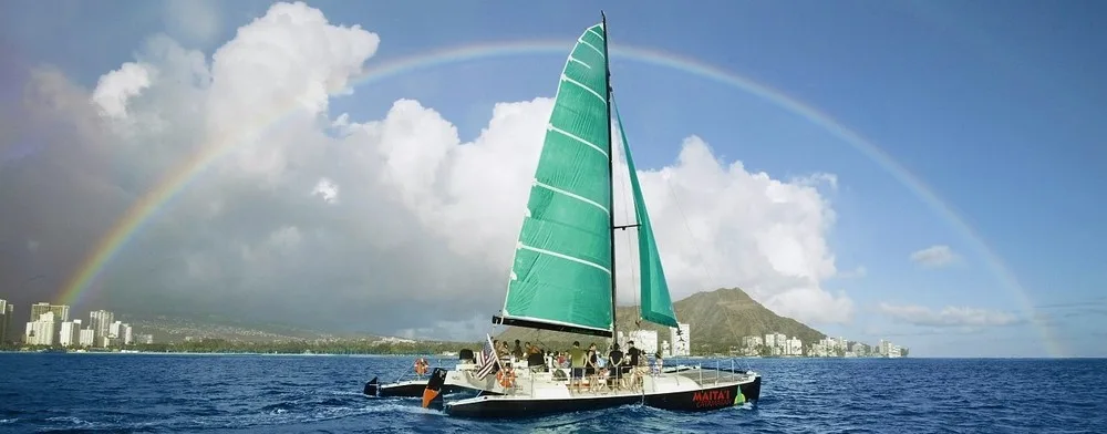 Sailboat cruising Waikiki with passengers enjoying drinks