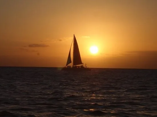 Boat sailing at sunset with passengers onboard