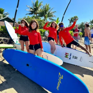 Surf instructor helping beginner catch wave in Lahaina