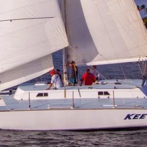 Private sailboat cruising Waimea Bay on sunny day