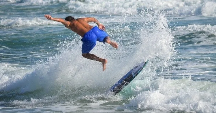 Boogie board lying on sandy beach near ocean