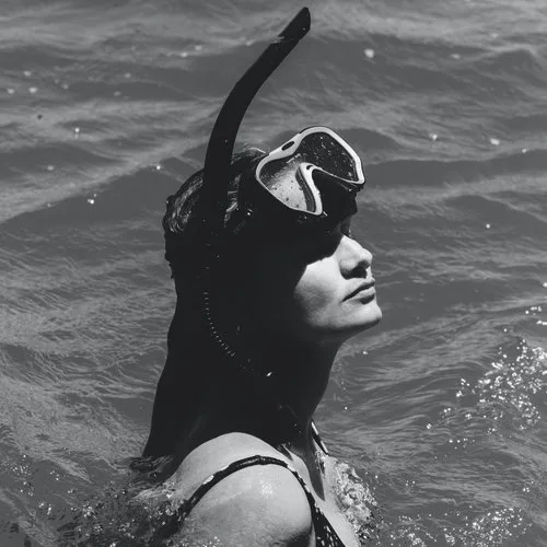 Snorkel mask and fins laid out on a beach towel