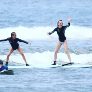 Surfboards lined up on sandy beach for clinic