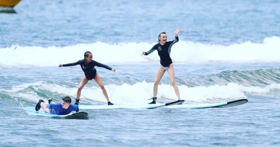 Surfboards lined up on sandy beach for clinic