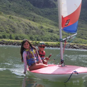Children learning to sail on calm ocean waters