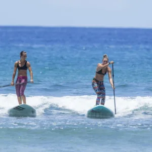 Group learning to stand-up paddleboard on ocean