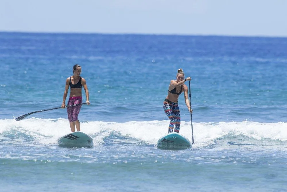Group learning to stand-up paddleboard on ocean