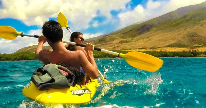 Kayakers paddling on calm waters near Maui shoreline