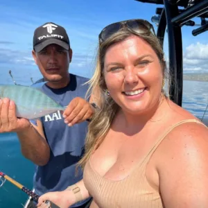 Family fishing together on boat in calm ocean waters