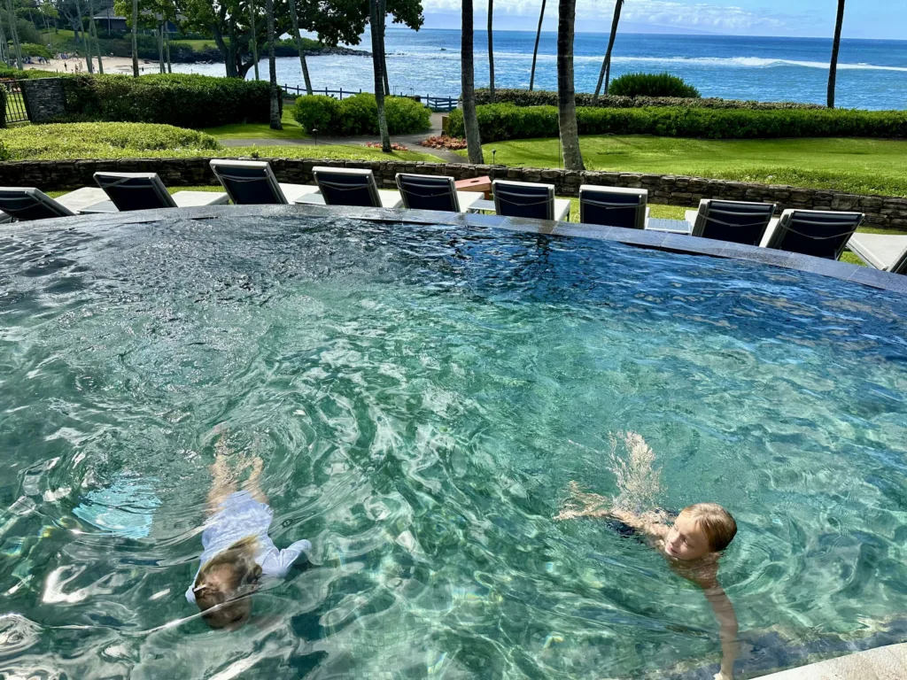 Children learning water safety skills in pool