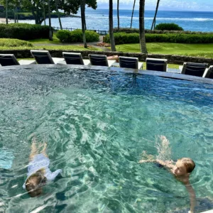 Children learning water safety skills in pool