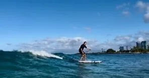Two people learning stand up paddleboarding with instructor