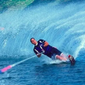 Person waterskiing behind a boat in calm marina waters