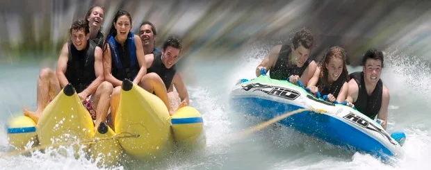 Six people holding on to a bright yellow banana boat