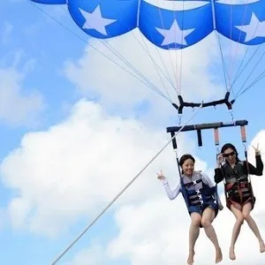 Wakeboarder riding wake behind luxury Nautique boat