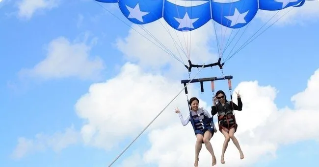 Wakeboarder riding wake behind luxury Nautique boat