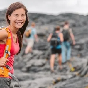 Hikers walking through lava tube and forest trail
