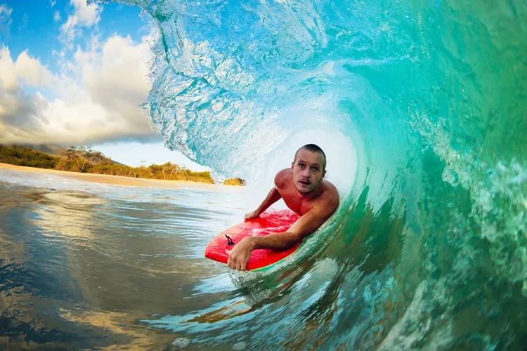 Colorful body boards lined up on sandy beach