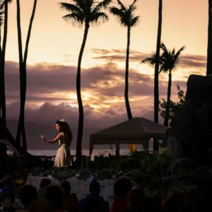 Performers dancing hula on stage at a Hawaiian luau