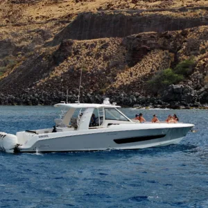 Luxury boat cruising near Maui coastline at sunset