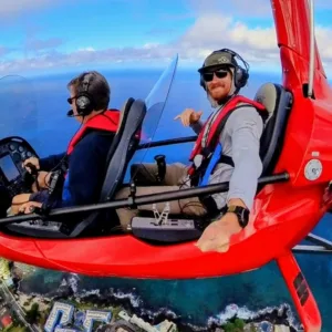 Gyroplane flying over Kona coastline with instructor