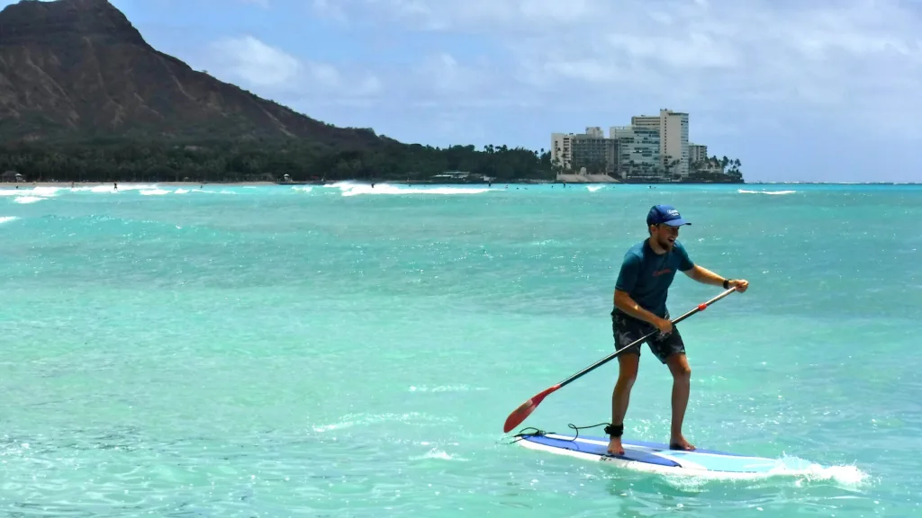 Instructor teaching standup paddleboarding on calm water