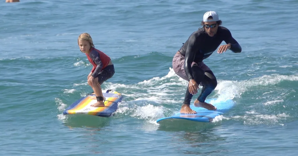 Children learning to surf on gentle waves