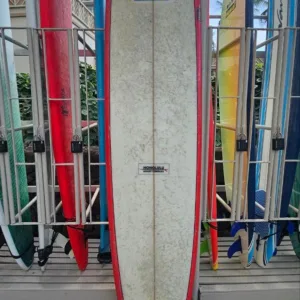 Fiberglass 9-foot surfboard standing upright by locker