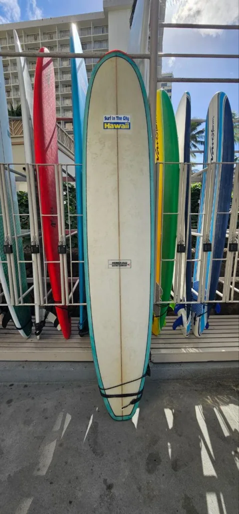 9ft fiberglass surfboard leaning against Waikiki locker