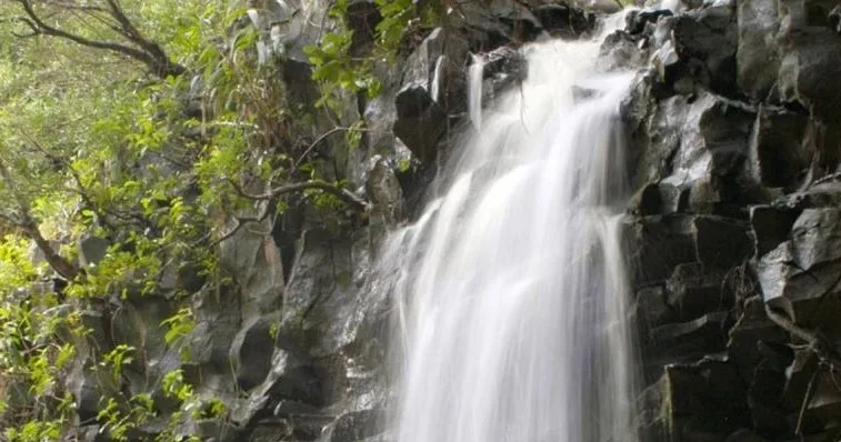Kayakers paddling along rugged Maui coastline