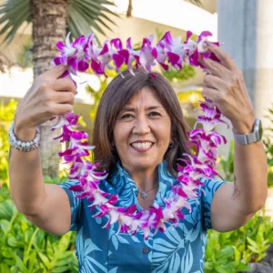 Orchid lei held by greeter at Kona Airport