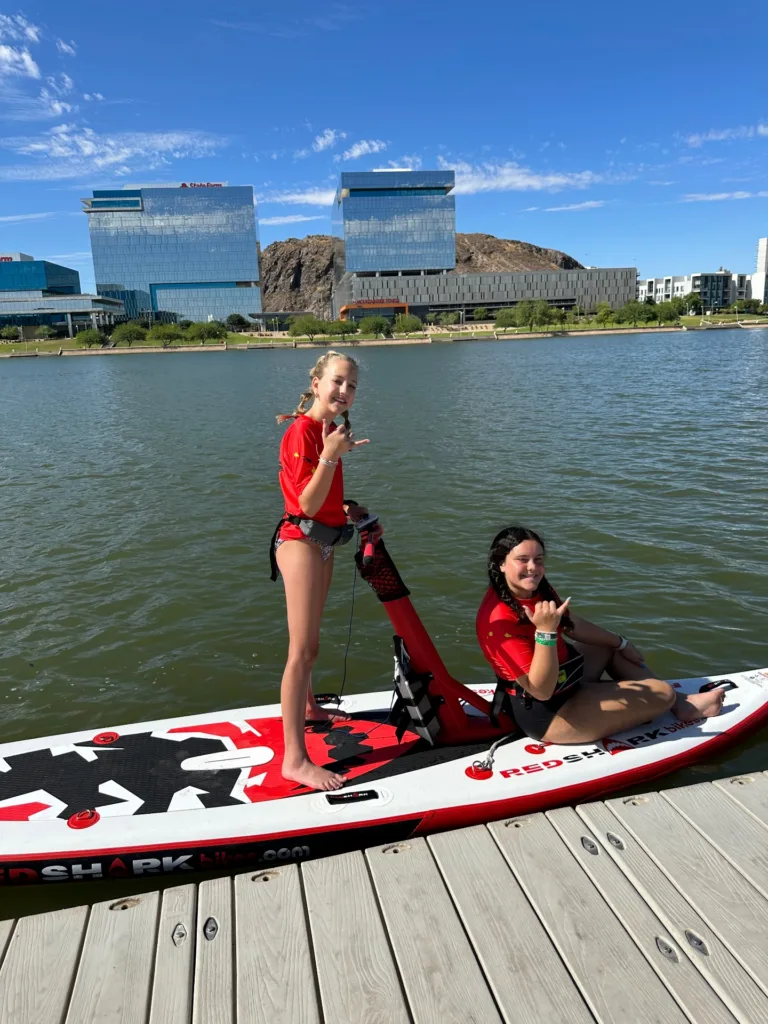 Person pedaling inflatable Red Shark water bike