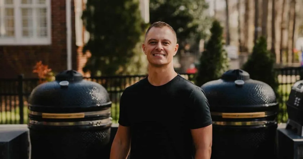 Outdoor BBQ event with chef grilling meats at sunset