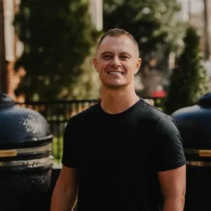 Outdoor BBQ event with chef grilling meats at sunset