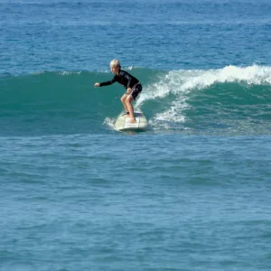 Children learning to surf with instructor