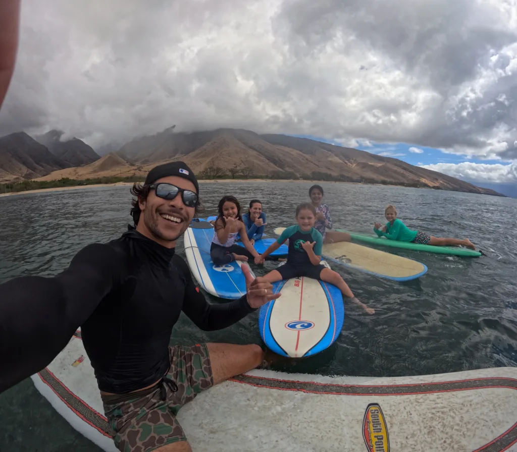 Kids learning to surf in small group lesson