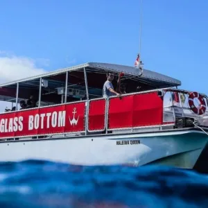 Glass bottom boat cruising over clear Hawaiian waters