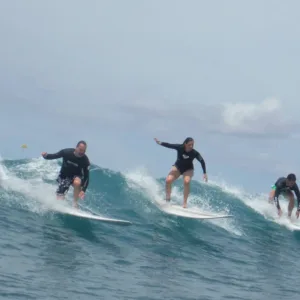 Group surf lesson participants waiting on beach