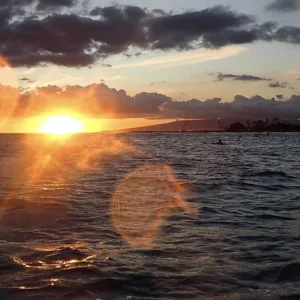 Person paddle boarding at sunset near Waikiki Beach