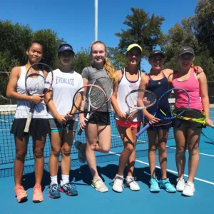 Junior tennis players competing in invitational match