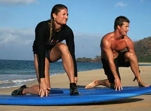 Surfing lesson on sandy beach with instructor