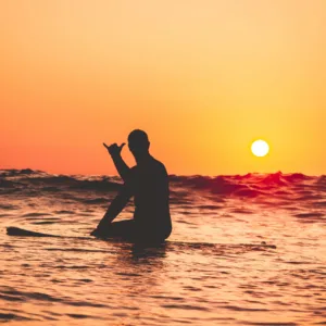 Surfer catching wave during sunset lesson
