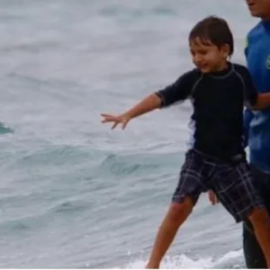 Surf instructor teaching beginner on North Shore beach