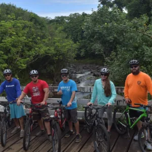 Bicyclists riding along old highway through forest