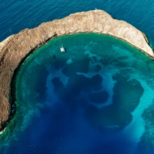 Luxury catamaran sailing near Molokini Crater at sunrise