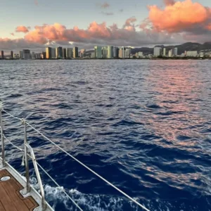 Sailboat silhouetted against a colorful Oahu sunset sky
