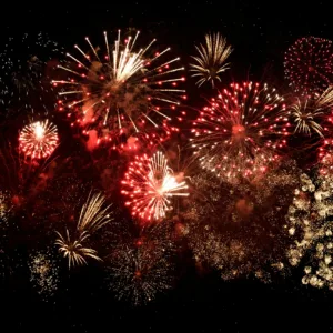 Family enjoying fireworks from a catamaran at night