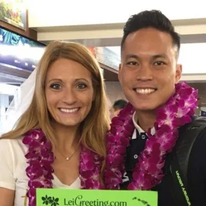 Couple wearing fresh flower leis at Hawaiian airport
