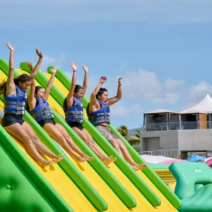 Children climbing and sliding on floating water obstacle course