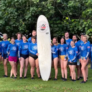Large group preparing for corporate surf lesson at beach